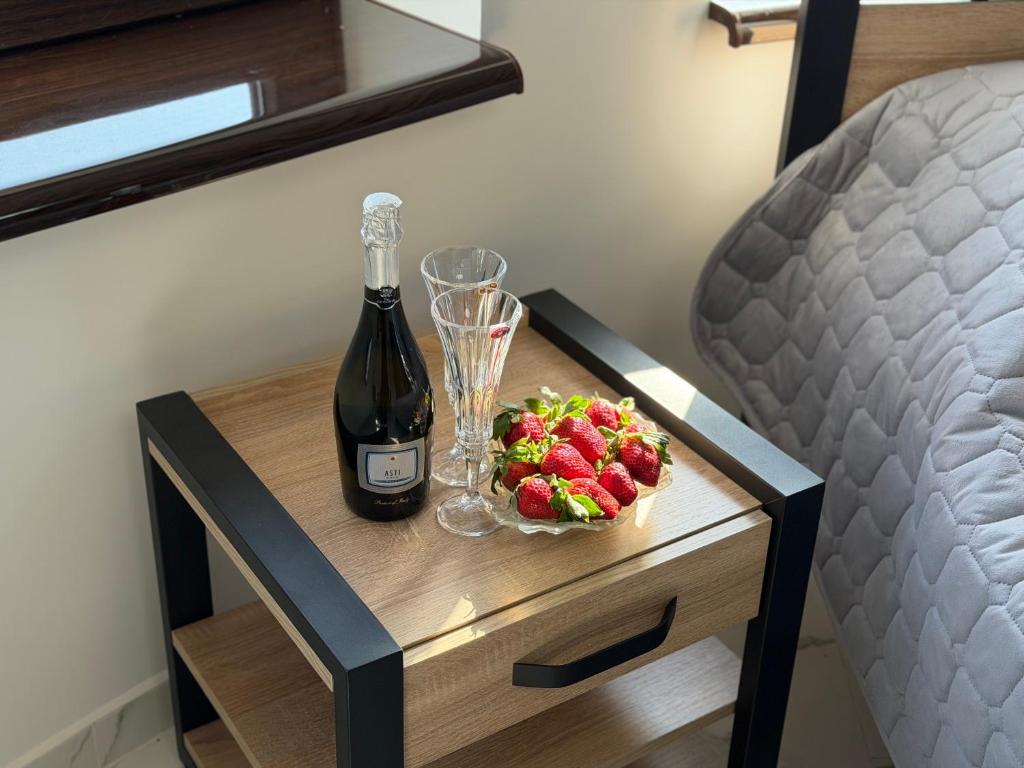 a bottle of wine and a bowl of strawberries on a table at film in Solotvyno