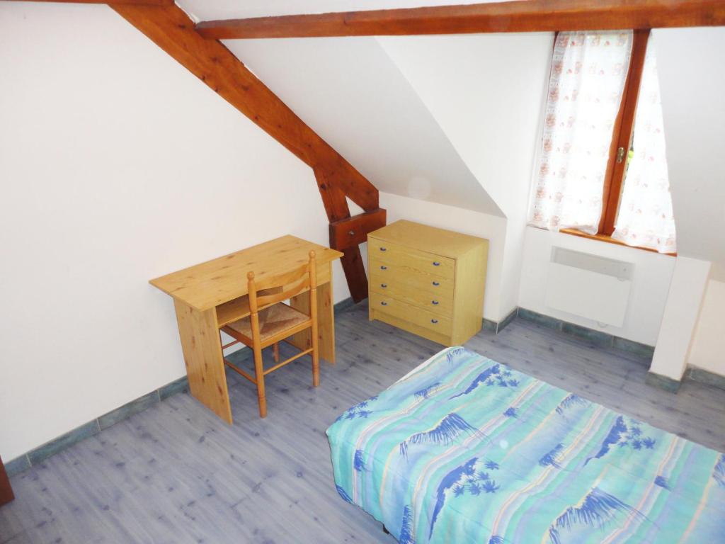 a bedroom with a desk and a bed and a table at Gite De l'Augereau in Céré-la-Ronde