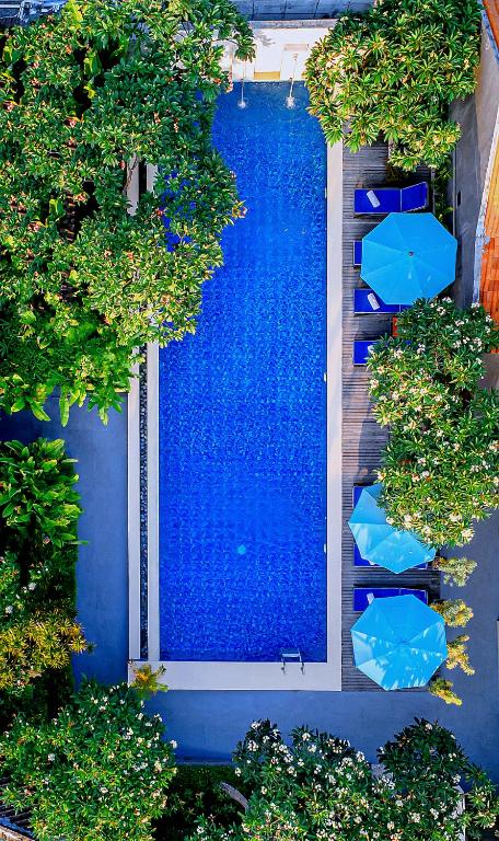 an overhead view of a swimming pool with blue umbrellas at Rama Residence Seminyak in Seminyak