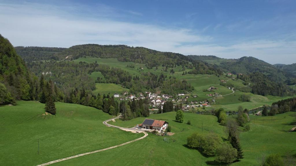 an aerial view of a village in a green field at Le Cras in Soubey