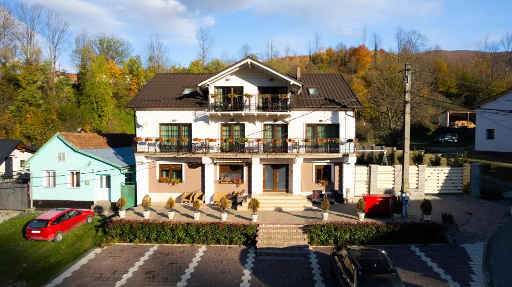 a large white house with a balcony on top of it at Casa Caius in Văliug