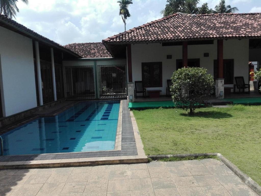 a house with a swimming pool in the yard at Maple Suite in Kadawata
