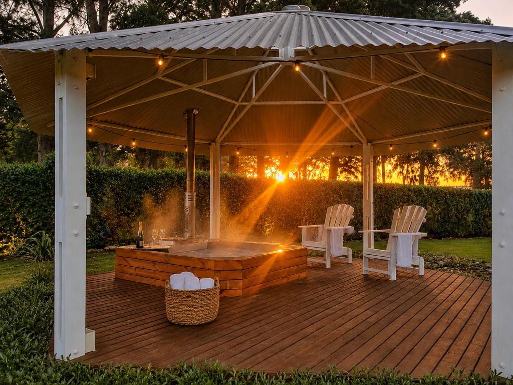 a gazebo with a fountain and two chairs at Swannie Creek private nature retreat with hot tub and fireplace in Grabouw