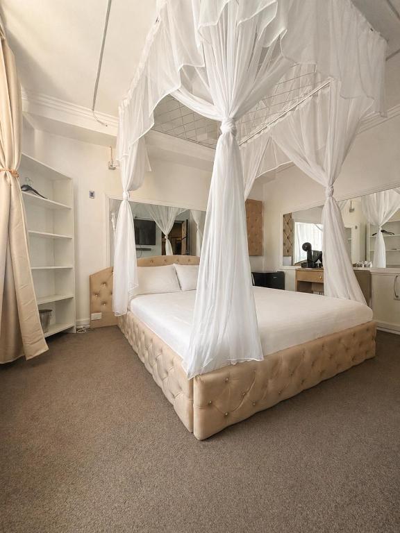 a bedroom with a canopy bed with white drapes at Hotel Boutique18plus - Adults Only in Mamaia Sat/Năvodari