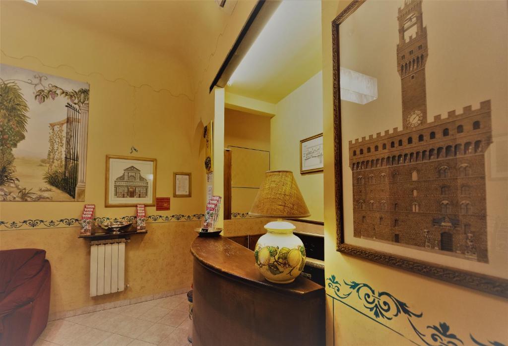 a room with a mirror and a lamp on a desk at Hotel Palazzuolo in Florence