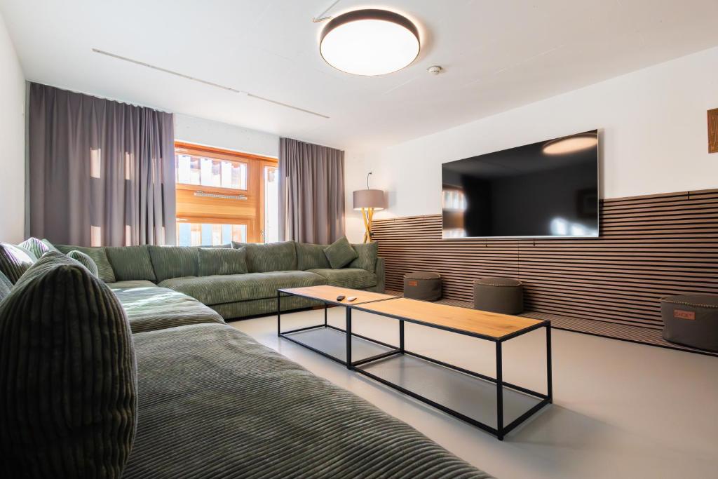 a living room with a couch and a table at Vercorin group lodge 18 people in Chalais