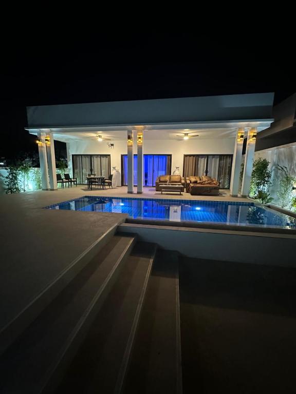 a house with a swimming pool at night at AVANA Villa in Nathon Bay