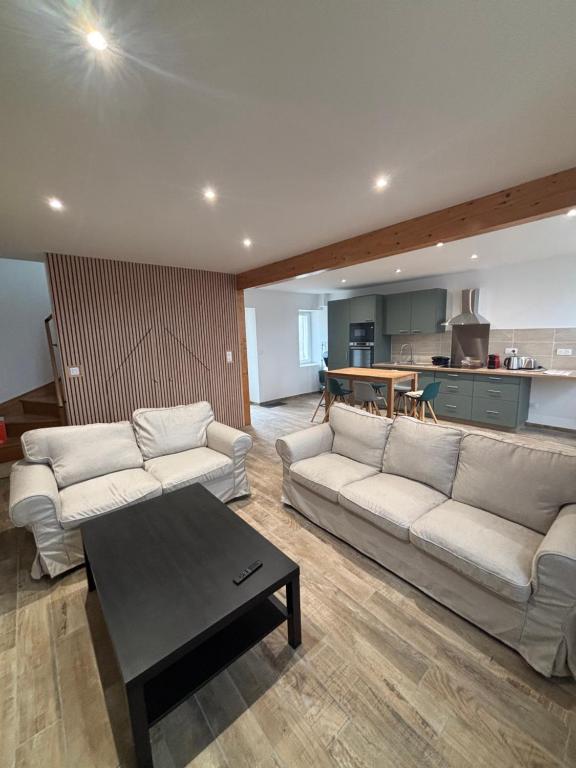 a living room with two couches and a table at Gîte des vignobles de Reuilly in Reuilly