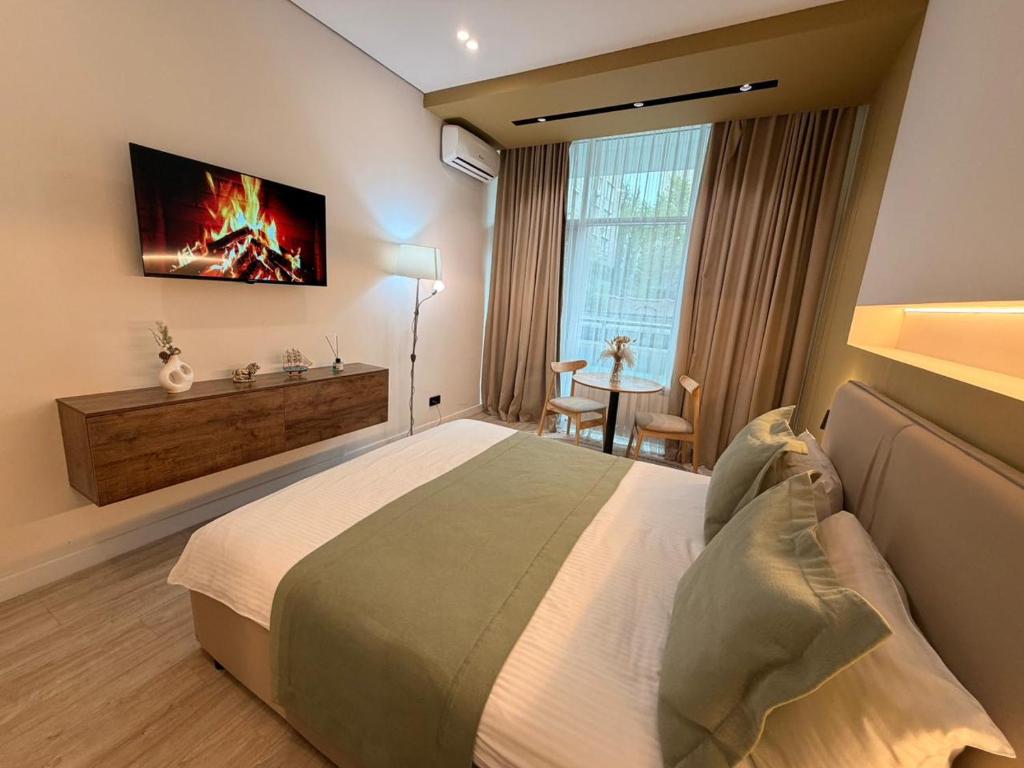 a hotel room with a bed and a television on the wall at Sea Star Boutique Hotel in Almaty