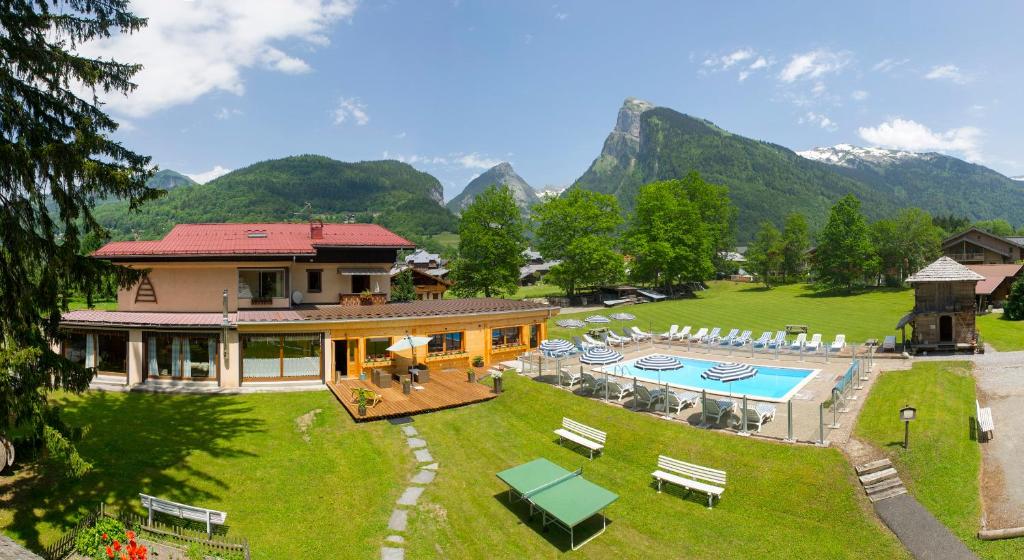 una vista aérea de una casa con piscina y montañas en Résidence La Cour en Samoëns