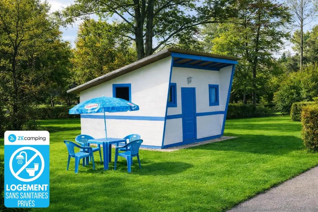 a small shed with a table and chairs and an umbrella at ZEcamping 3 étoiles familial avec Piscine et Bar-restaurant in Saint-Honoré-les-Bains