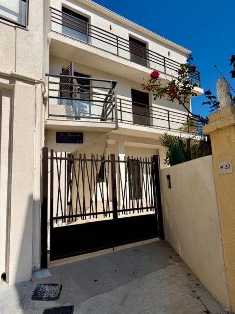 a white building with a black gate and a balcony at Studio Noélie in Antibes