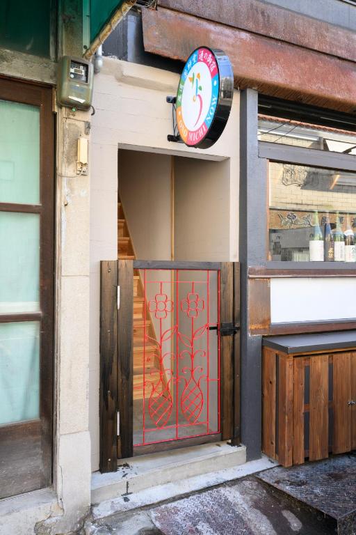 a store front with a red door and a sign at NOW Onomichi in Onomichi