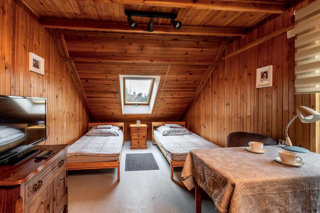 a room with two beds in a wooden cabin at Nostalgia noclegi in Olsztyn
