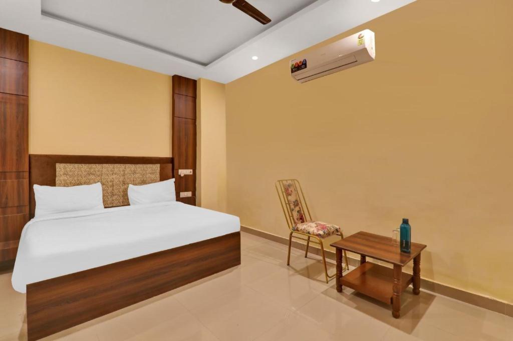 a bedroom with a bed and a table and a chair at Amba heritage house in Prayagraj