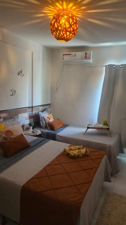 a room with two beds and a light at Apto Beira Mar - Enseadas dos Corais in Cabo de Santo Agostinho