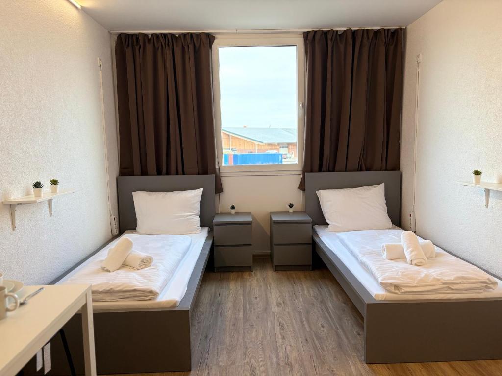 two beds in a room with a window at Stäy Gronau in Am Berge