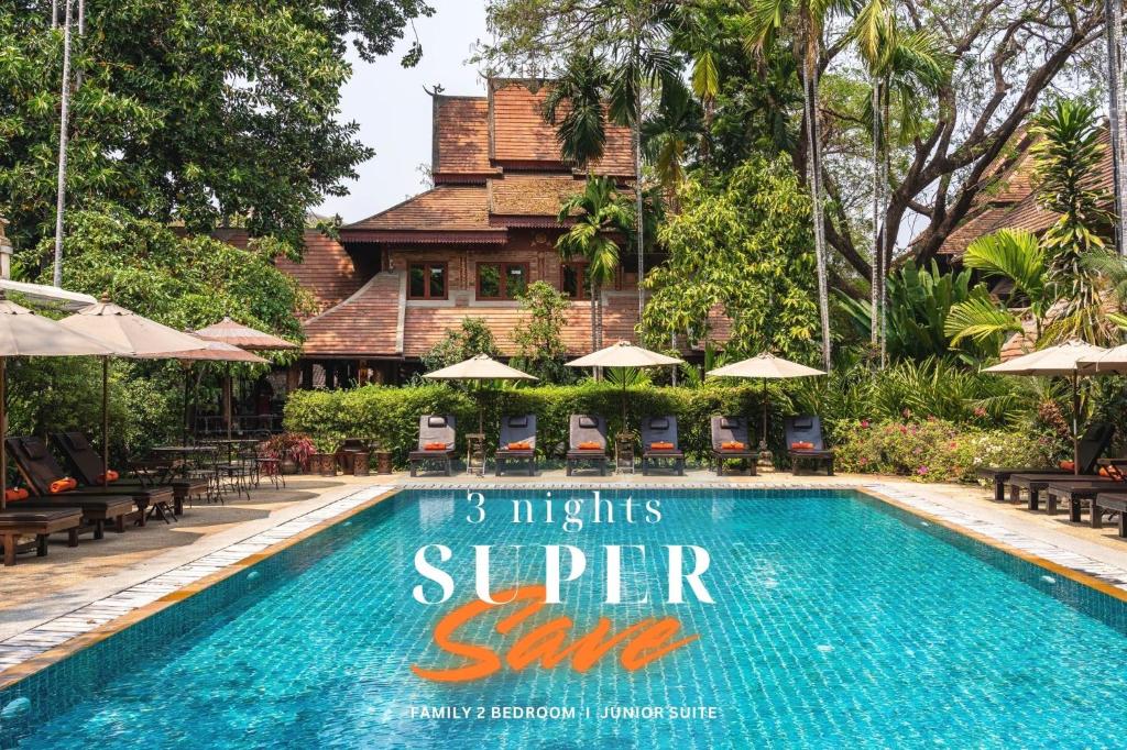 a resort swimming pool in front of a building at Yaang Come Village Hotel in Chiang Mai