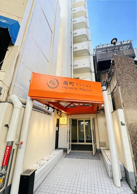 an entrance to a building with an orange awning at サムティ扇町 in Osaka