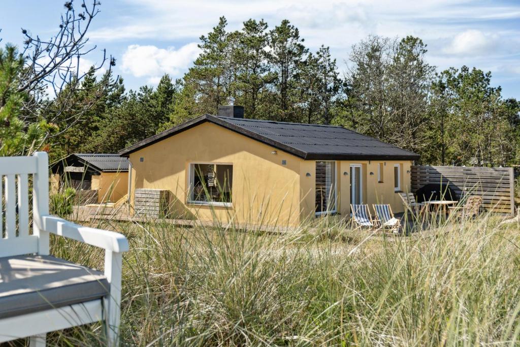 a house with a solar roof in a field at Stone House's Simplicity In Jerup's Vicinity in Jerup