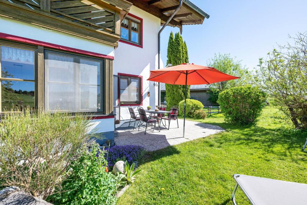a patio with an umbrella and a table and chairs at Ferienwohnung am Schusterhof in Wonneberg