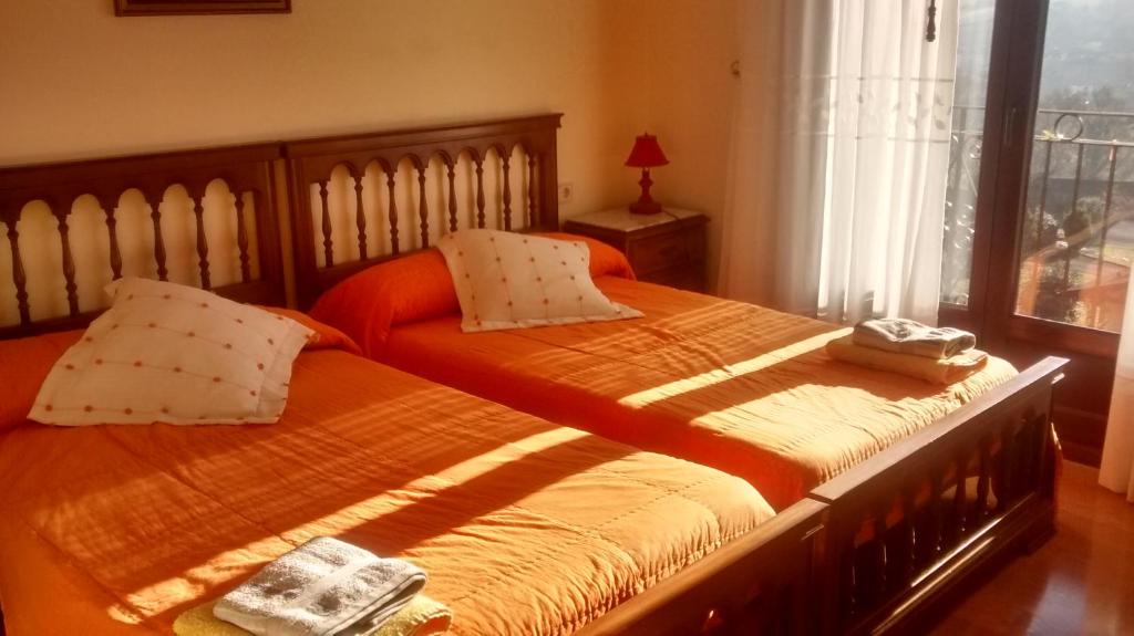 two twin beds in a bedroom with a window at Txantxikonea Etxea in Elizondo