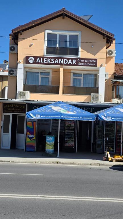 a building with two blue umbrellas in front of it at ALEKSANDAR - luxury stay private guest rooms in Gotse Delchev