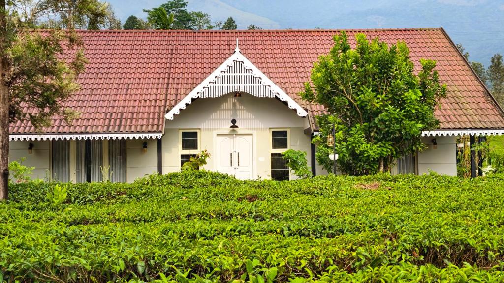 a small white house with a red roof at Estate IV - Saffron Suite - Tea Estate Stay in Vythiri