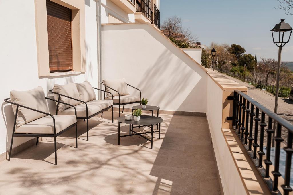 a patio with chairs and a table on a balcony at Alojamientos Estrella Baeza in Baeza