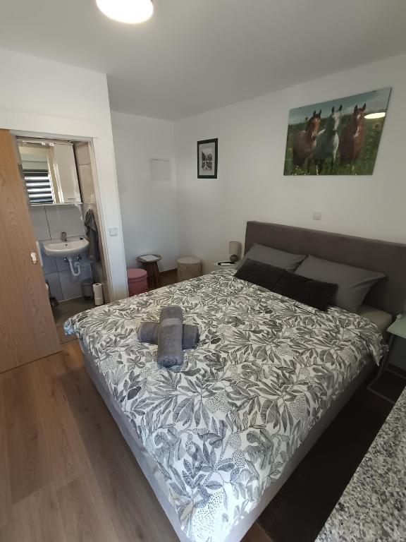 a bedroom with a bed with a gray comforter at Sleepover Room K&M in Novoselec