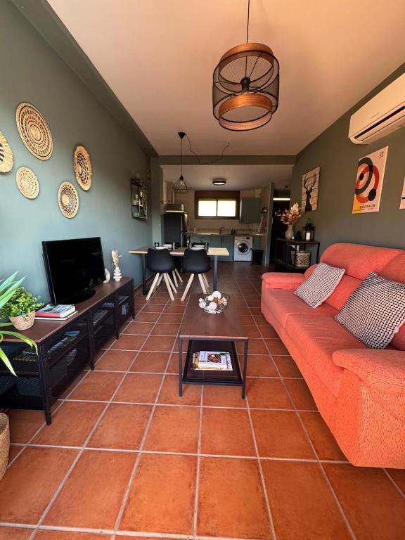 a living room with a red couch and a table at El Mirador de Adrial in Ladrillar