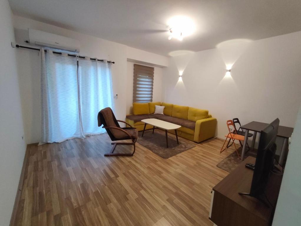 a living room with a yellow couch and a table at Sunny Pine Apartment Mavrovo in Mavrovo