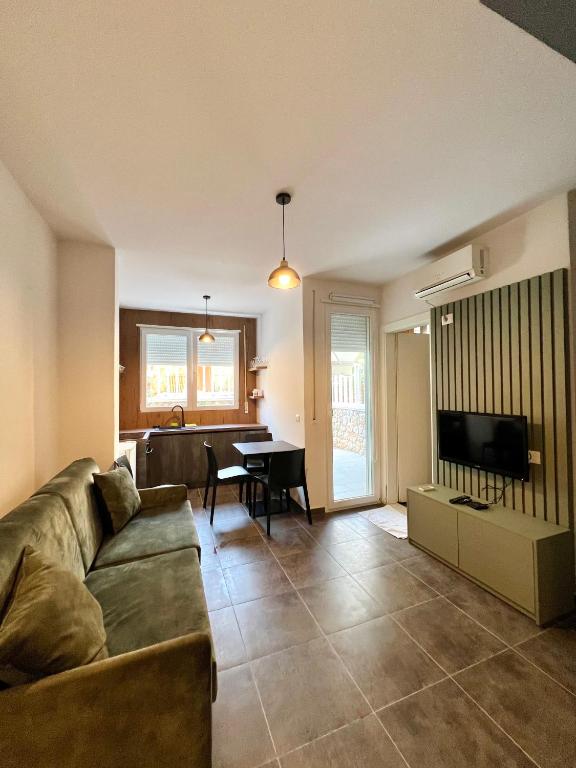 a living room with a couch and a table at Beach Studio Apartment in Dhërmi