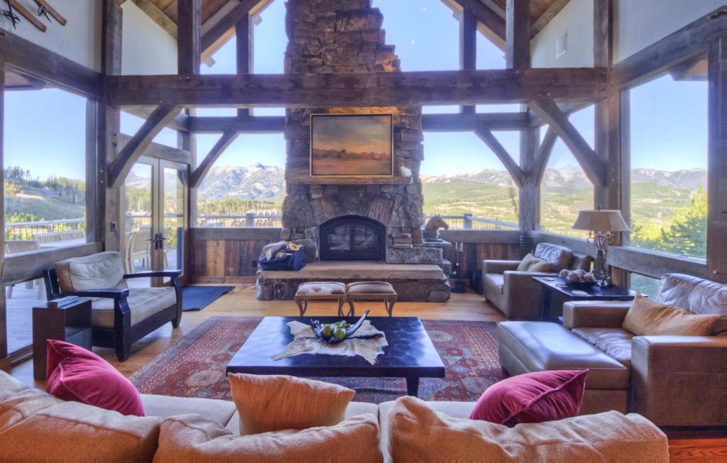 uma grande sala de estar com uma grande lareira de pedra em Latigo Lodge em Big Sky Mountain Village