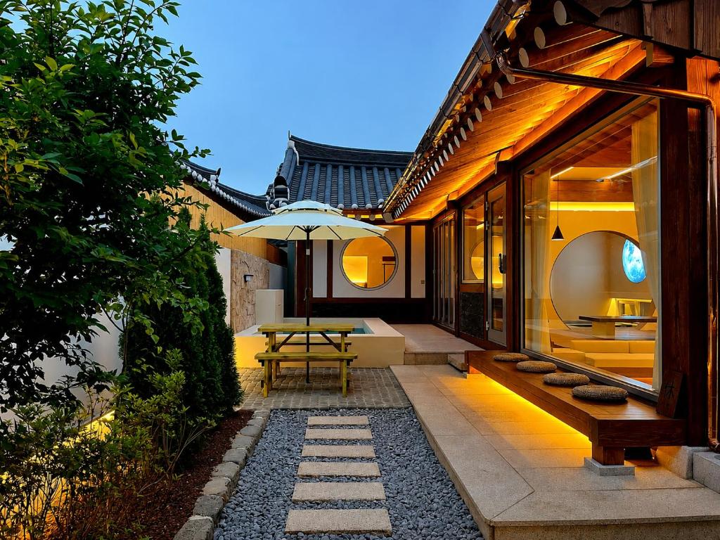 a patio with a table and an umbrella on a house at Hyu Stay in Gyeongju
