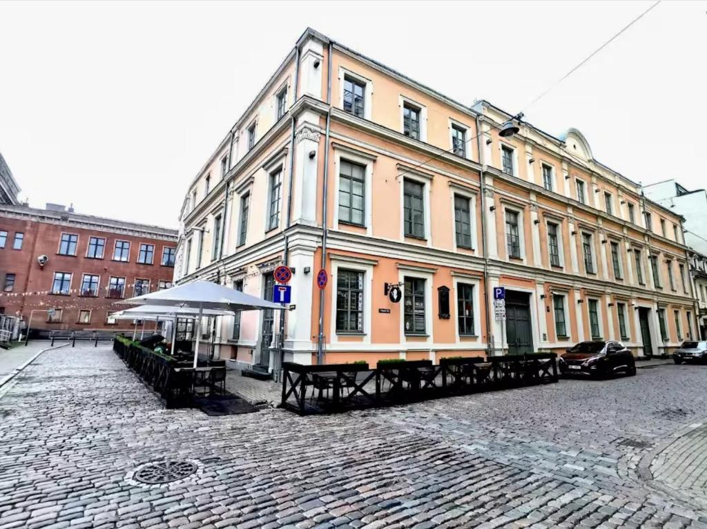 a large building on a street with tables in front of it at Spacious 2 bedroom apartment, Old Town Riga in Riga