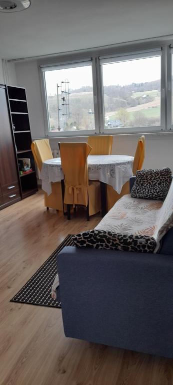 a living room with a table and chairs and a couch at Apartament Biedronka in Nowa Ruda
