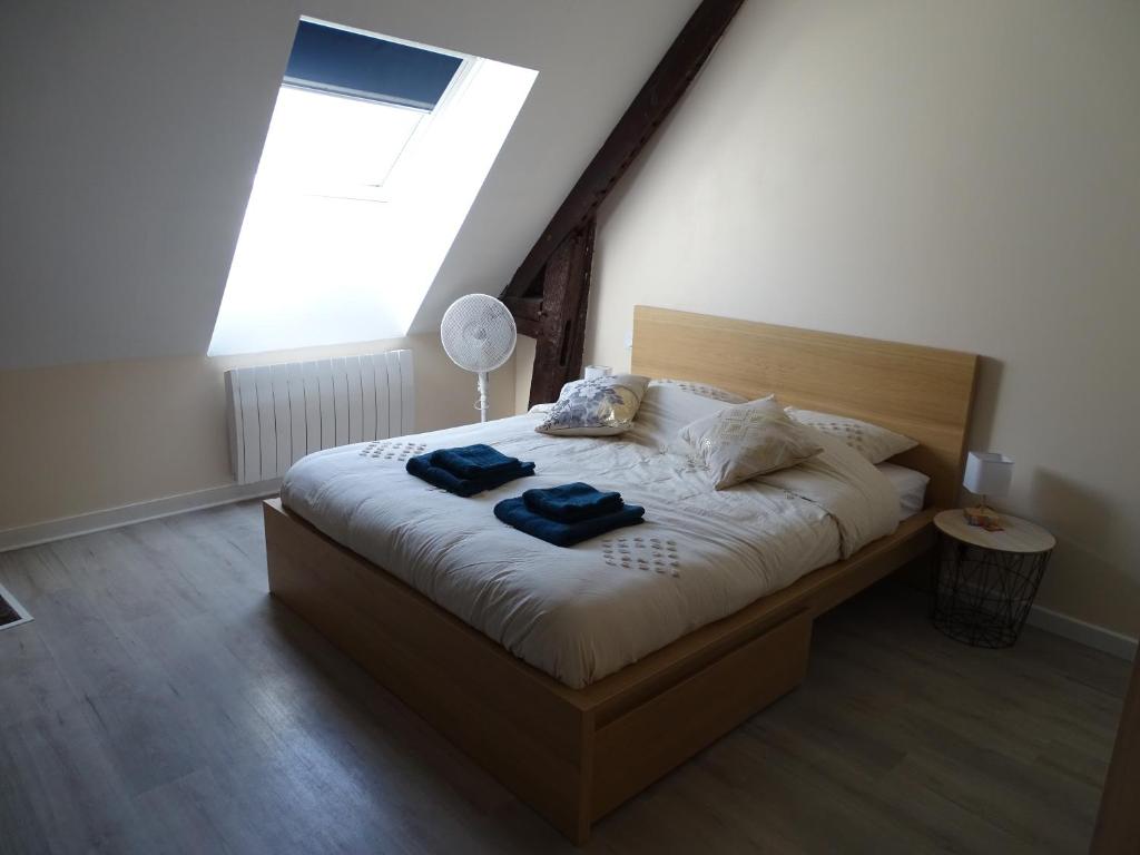 a bedroom with a bed with two blue towels on it at Chambre Ecuador in Châteaubourg