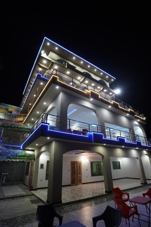 a large building with a balcony and chairs at night at Koh E Sukoon Apartments in Patriata