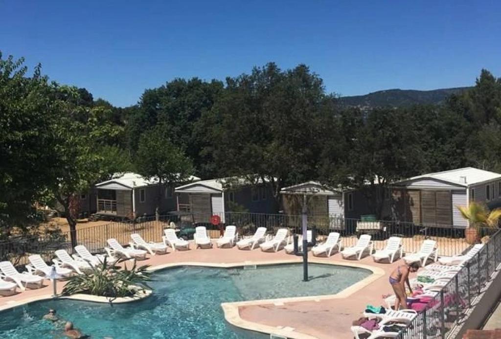 a swimming pool with lounge chairs and a swimming poolvisorvisor at ZEcamping 3 étoiles à 4km de la plage piscine chiens acceptés jacuzzi in Bormes-les-Mimosas