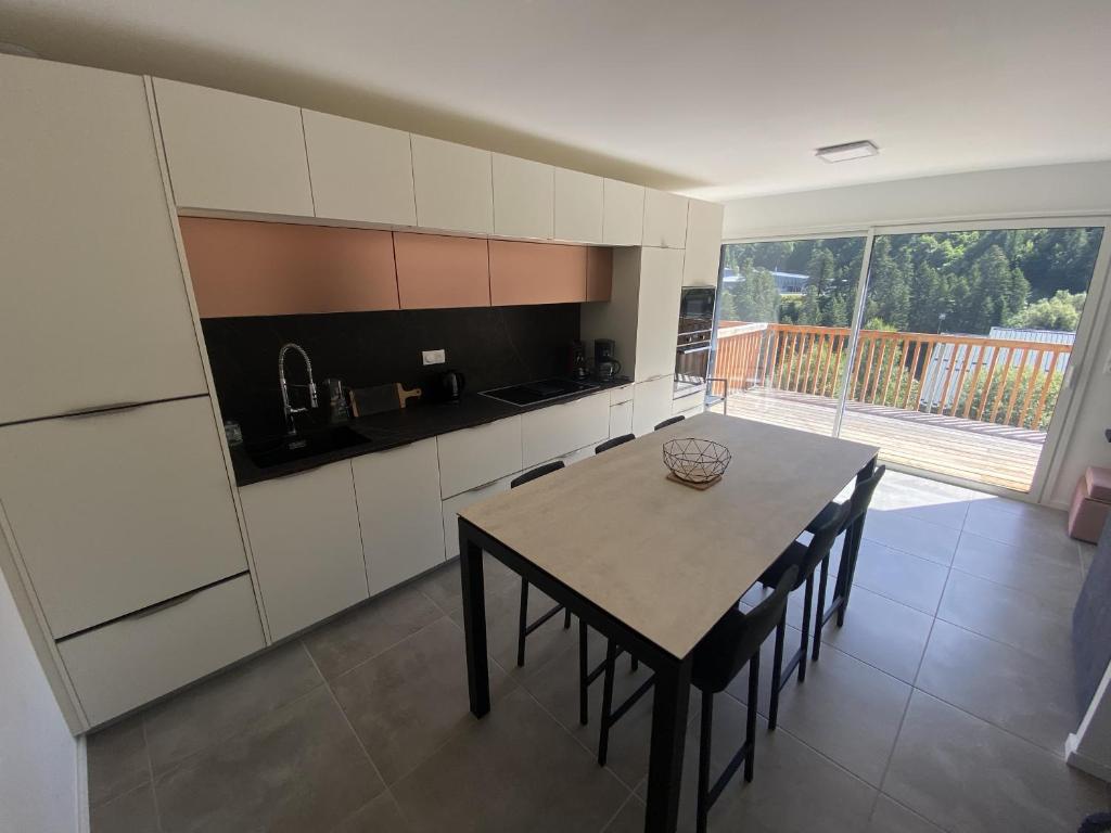 a kitchen with a table and chairs in a room at Duplex 3 chambres Etoile du sud in Le Lioran