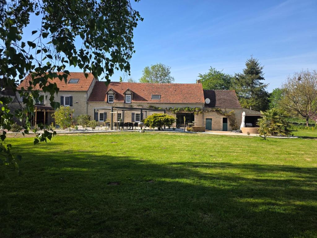 a large house with a large lawn in front of it at Villa du Marais in Ri