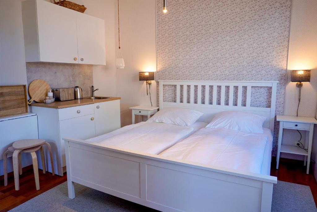 a large white bed in a room with a kitchen at Ferienwohnung LOTTTALEBEN 2 in Timmendorfer Strand