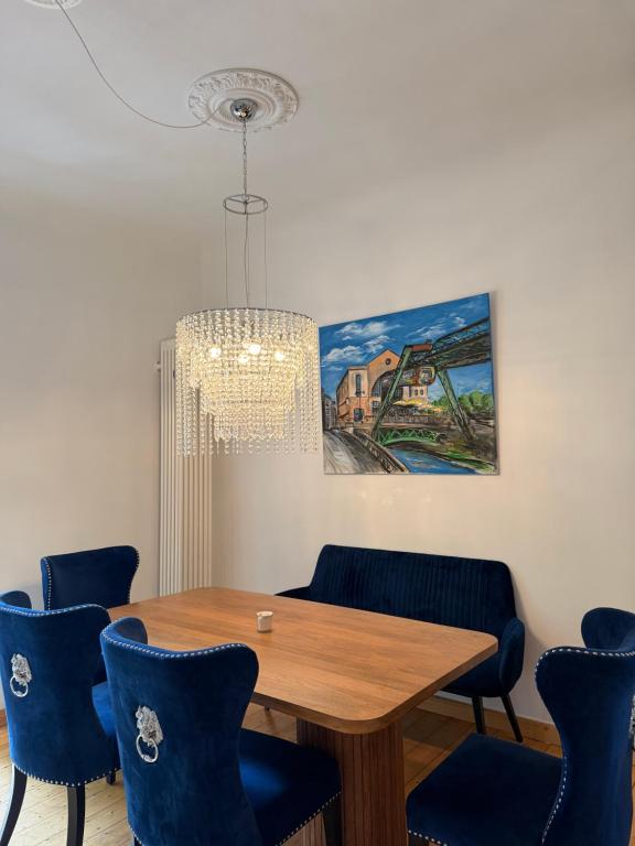 a dining room with a wooden table and blue chairs at Wunderschöne 2 Zimmer Wohnung in Wuppertal in Wuppertal
