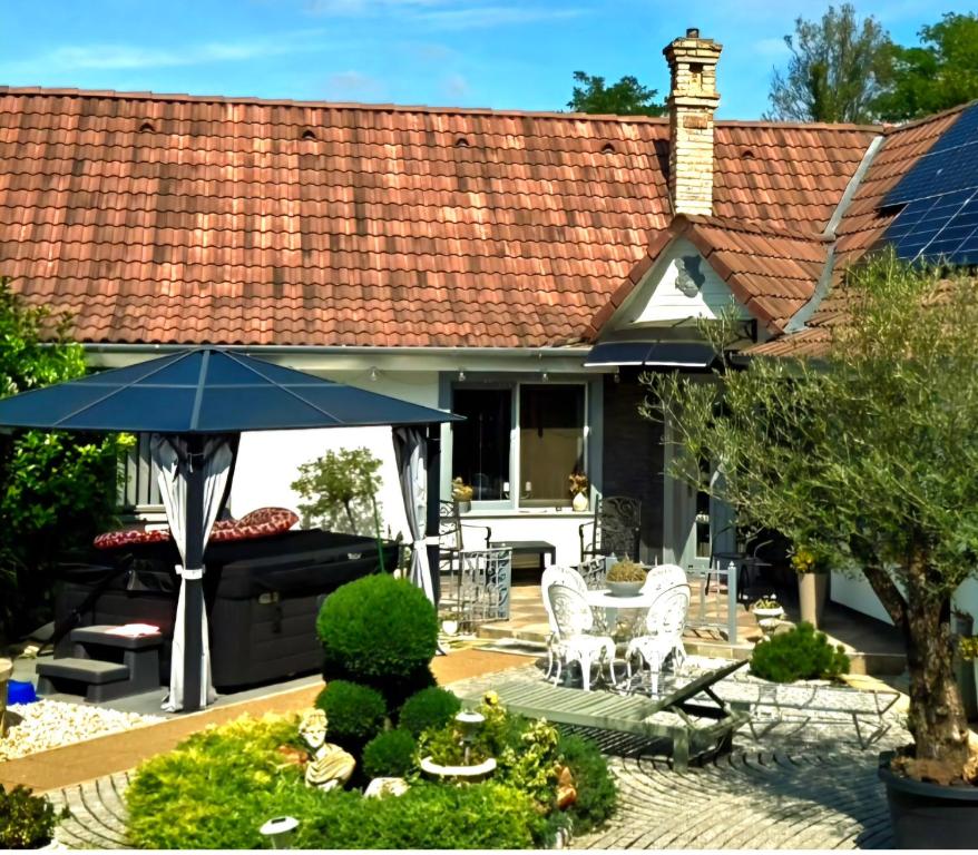 a house with a patio with an umbrella at Kristály Pihenőház in Szekszárd