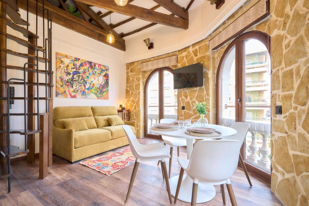 a living room with a table and chairs and a couch at Los Balcones de San Juan in Salamanca