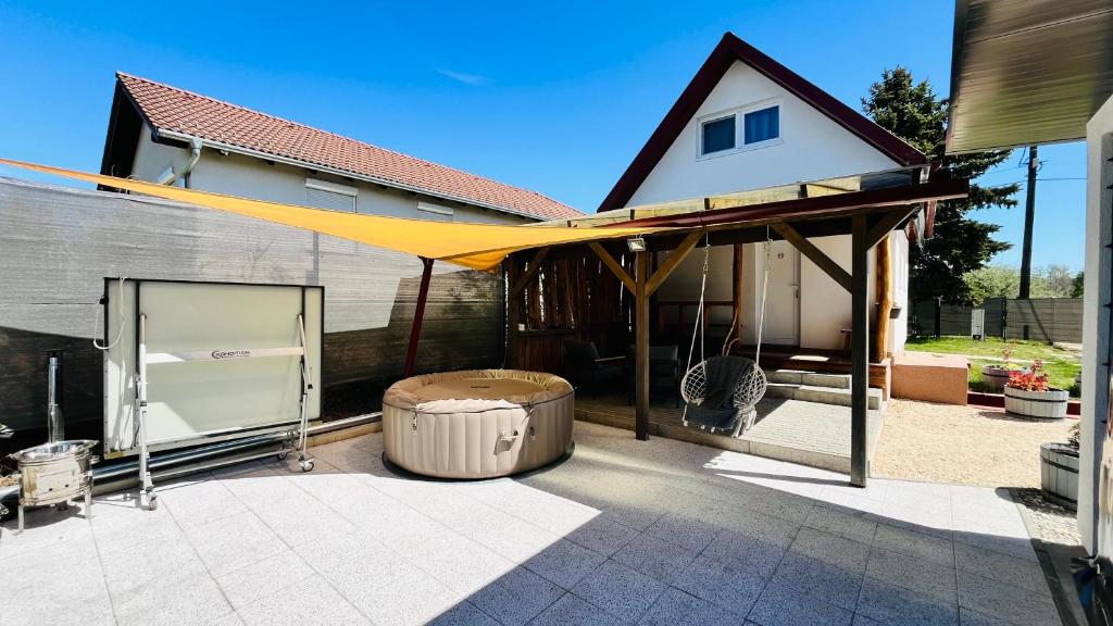 a patio with a yellow canopy in front of a house at Lebegő Falu Vendégház in Oroszlány