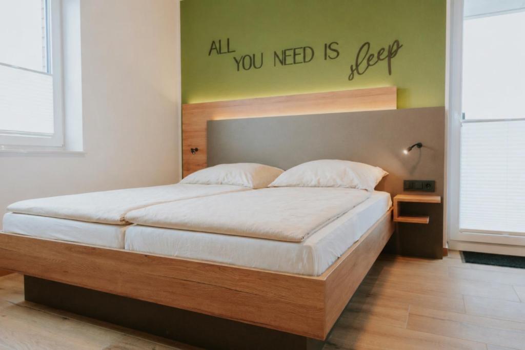 a bedroom with a bed with a sign on the wall at Stay2sleep, Self-Check-In in Dinklage