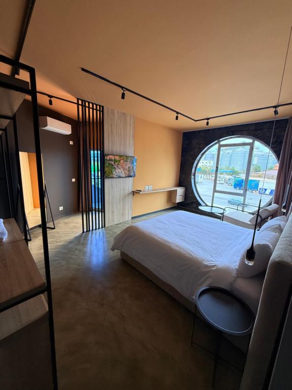 a bedroom with a bed and a large window at Hotel Omw Vore in Vorë