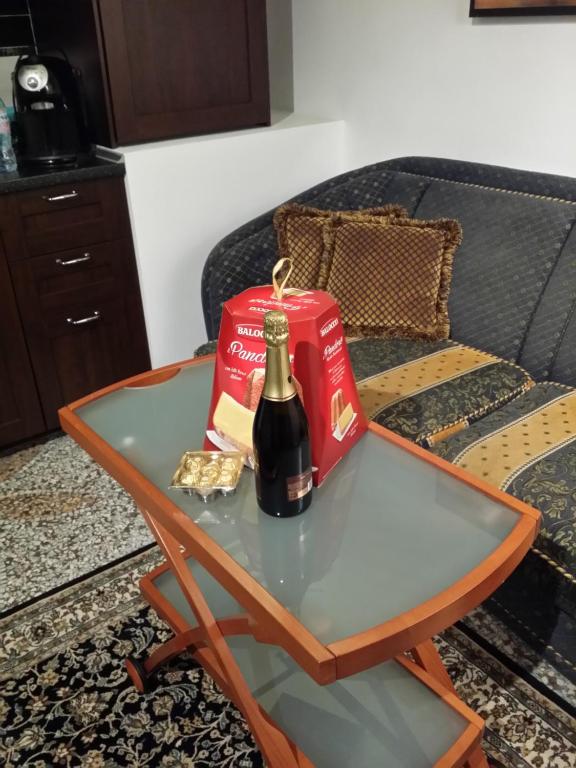 a bottle of wine on a table next to a couch at Felikshouse in Rome
